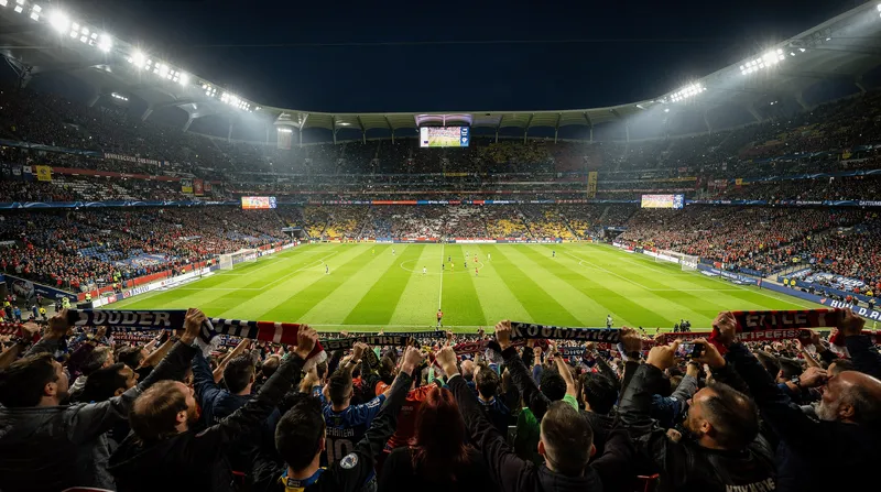 Packed stadium during a night match under floodlights