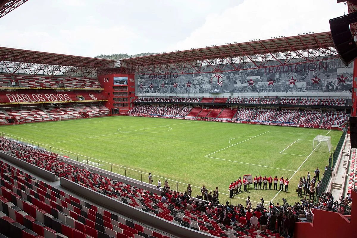 Estadio Nemesio Díez interior view showing the pitch and red stands before a Liga MX match