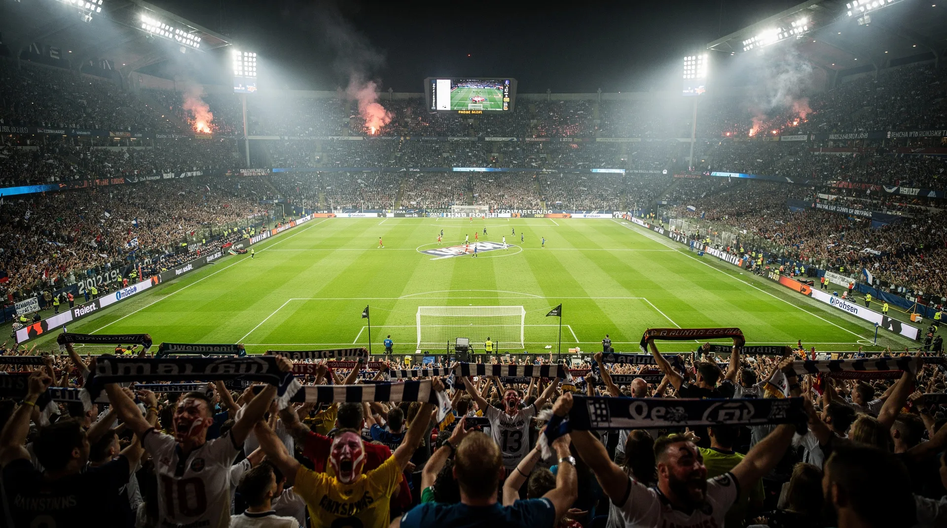Packed stadium during a night game under floodlights
