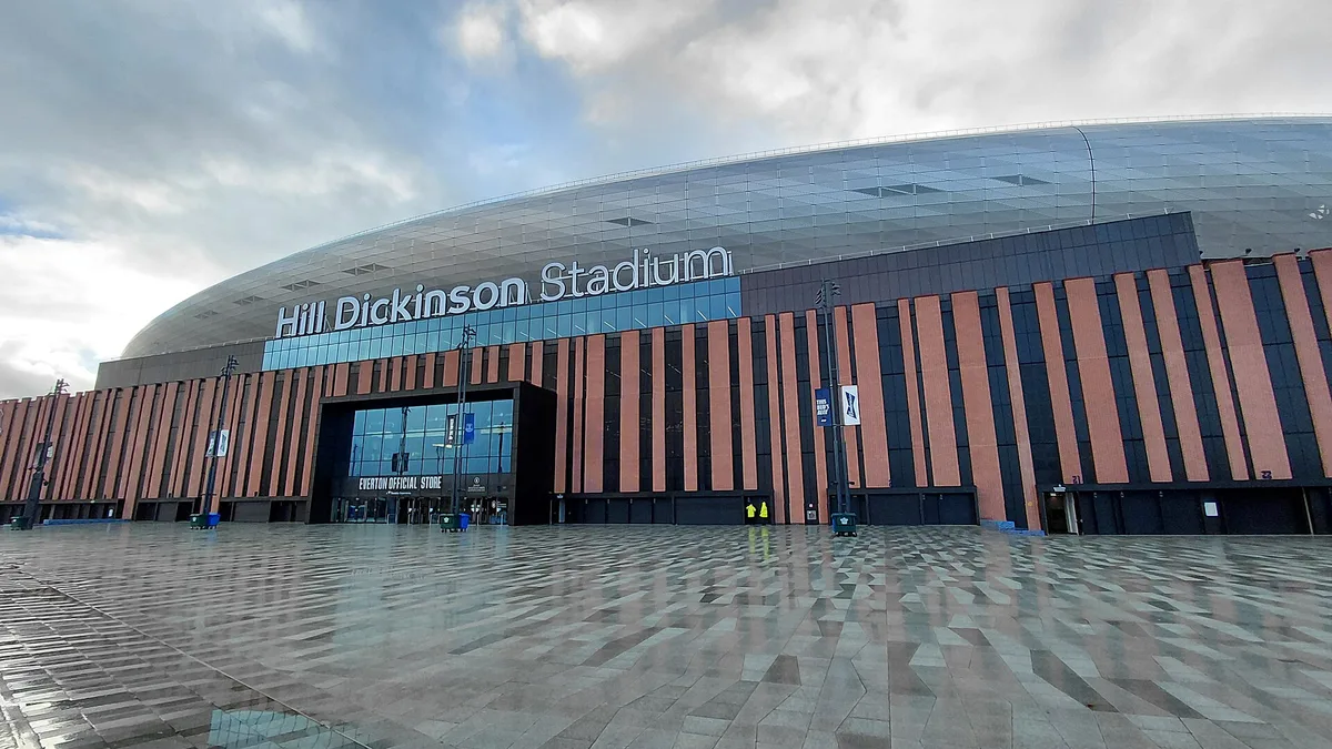 Hill Dickinson Stadium at Bramley-Moore Dock in Liverpool, the stadium name across the brick and steel facade above the club store