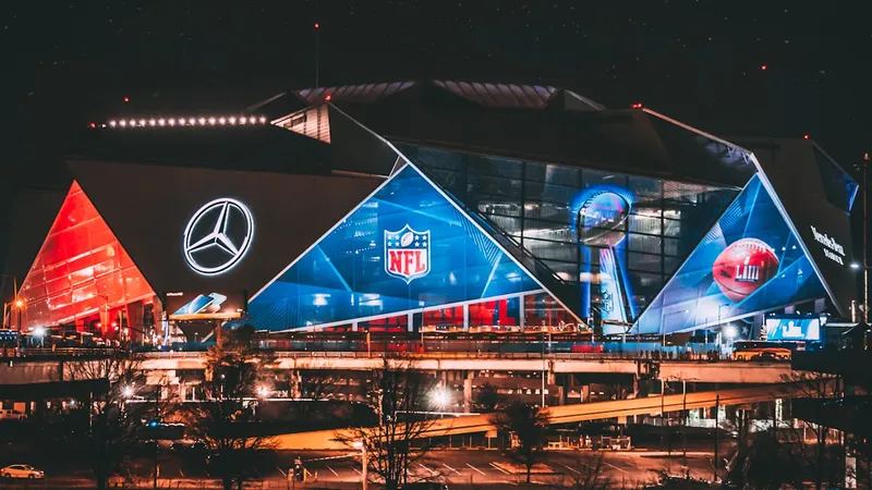Modern NFL stadium illuminated at night with dramatic lighting