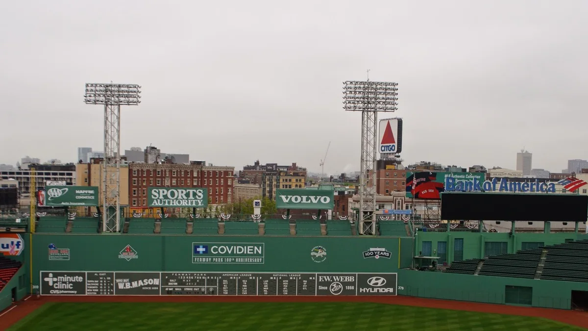 The Green Monster, hand-operated scoreboard and Monster seats at Fenway Park, with the Boston rooftops and the CITGO sign rising directly behind the left-field wall