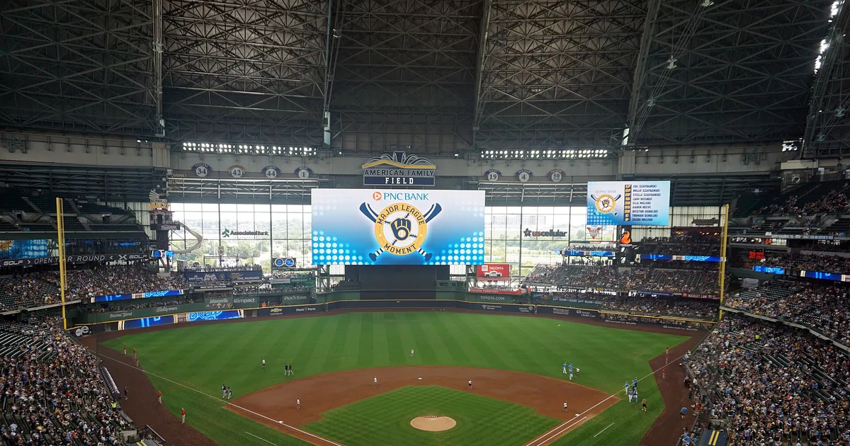 A packed American Family Field seen from the upper deck, roof closed, with the infield and scoreboard in view