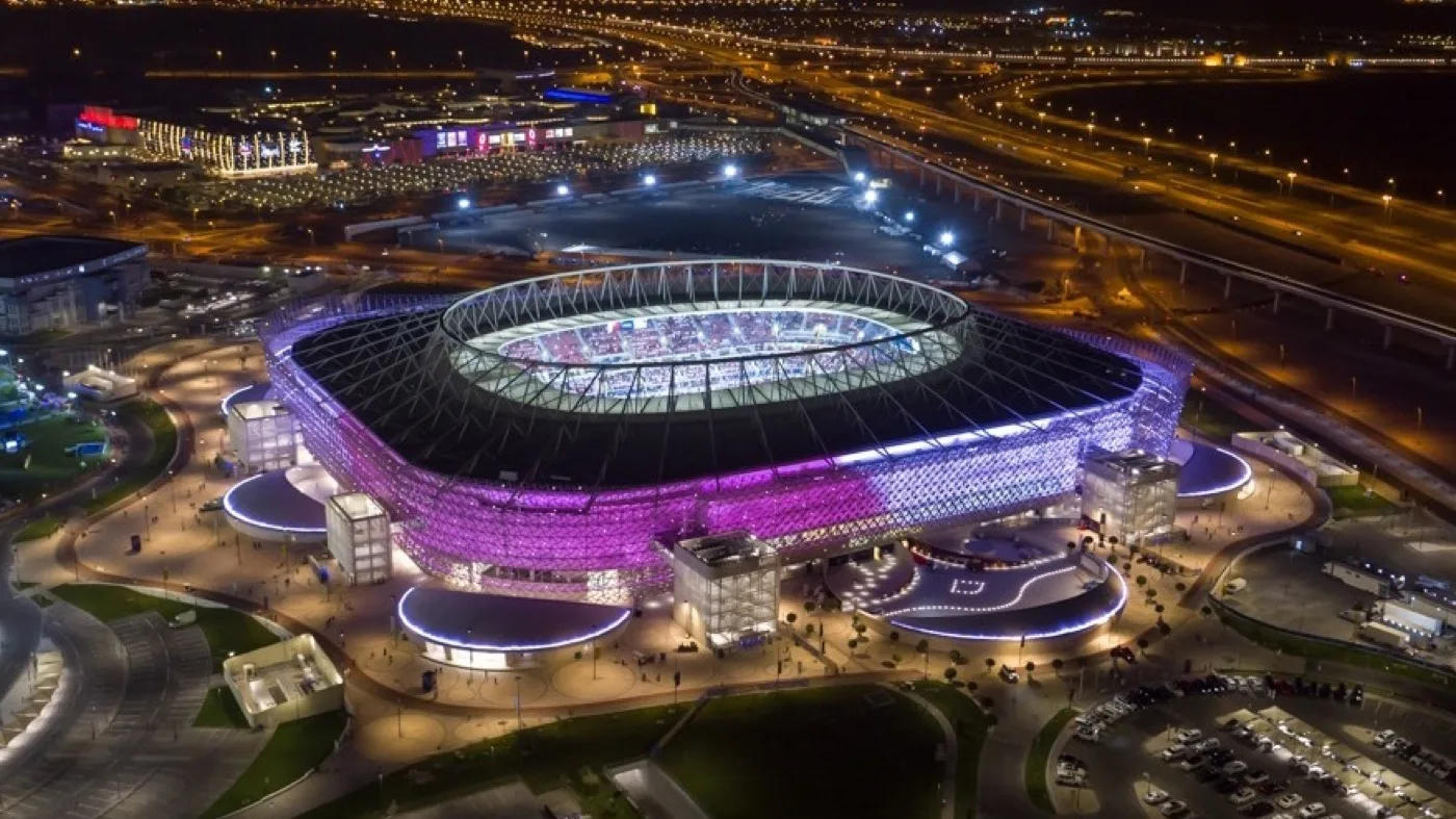 Ahmad bin Ali Stadium's undulating golden facade lit up in Al Rayyan